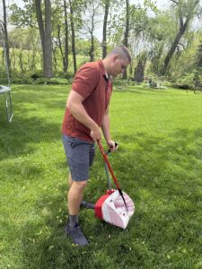 Ohio Pet Waste Pros owner with scooping bucket and rake in Holland cleaning poop