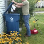 tech showing safe dog poop disposal. double bagged and placed in homeowner's garbage can in Maumee