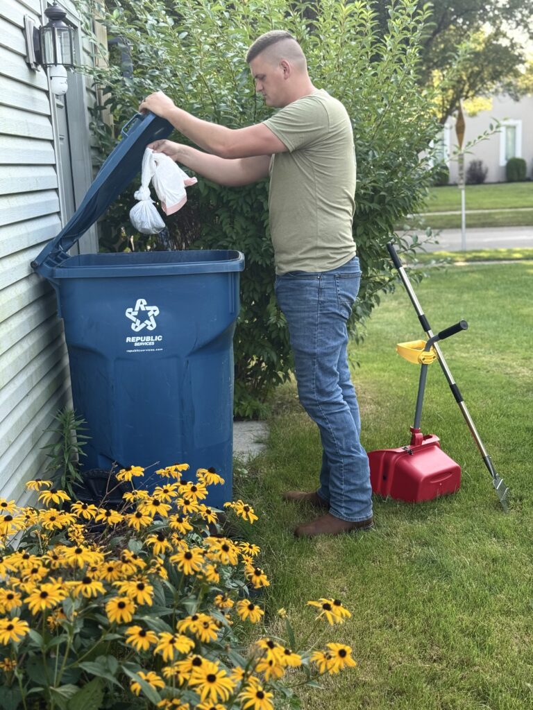 tech showing safe dog poop disposal. double bagged and placed in homeowner's garbage can in Maumee