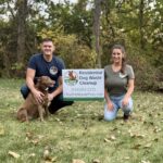 Dog poop removal technicians standing next to a sign in Holland, OH