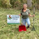 female dog poop removal technician in Toledo, OH with a sign