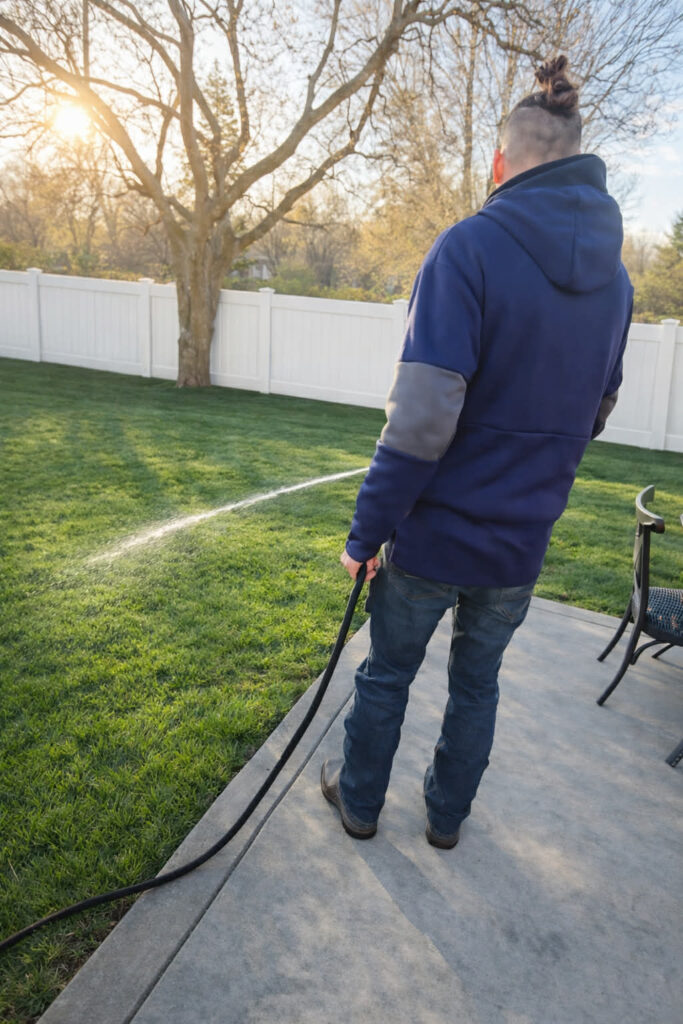 technician spraying a sanitizer to make a yard clean from poop and pee bacteria