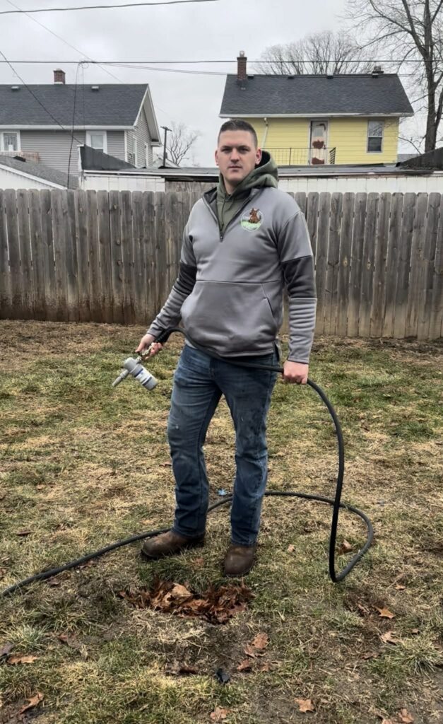 ohio pet waste removal owner applying sanitization to a yrda